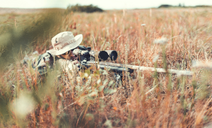 Header image. Sniper in a field looking at a target. Symbolizes a hunter tailing Apache log.